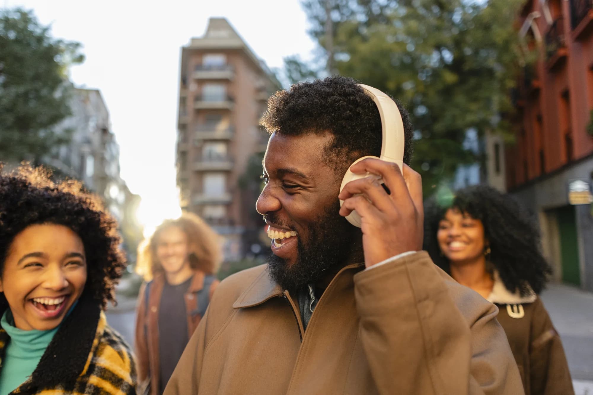 Friends walking together in the city with headphones